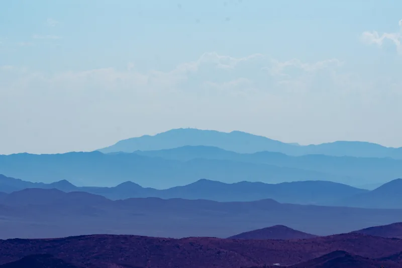Layered blue and purple desert ranges under a pale sky